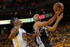 Basketbalista Parker se snaží dostat přes obranu Golden State