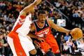 John Wall z Washingtonu proniká okolo Kyla Lowryho z Toronta