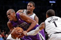 Basketbalista Sacramenta King Travis Outlaw se snaží probít mezi bránícími hráči Brooklyn Nets