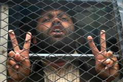 Jeden ze zadržených demonstrantů je odvážen do místního vězení