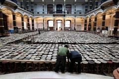 Assistants work on installation made of wooden stools by Chinese artist Ai Weiwei as part of exhibition 'Evidence' at Martin-Gropius Bau in Berlin