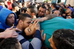 Palestinians shout slogans as they carry the body of militant Hamza Abu Alhija, in the West Bank refugee camp of Jenin