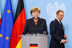 German Chancellor Merkel prepares to address to media as Polish PM Tusk looks on after their meeting in Warsaw