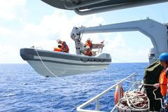 A search boat carrying rescue workers is set down from Mianyang warship on the waters suspected to be the site of the missing Beijing-bound Malaysia Airlines flight MH370