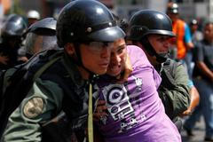 National guards detain a protester during riots in Caracas