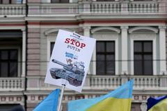 Ukraine's flags and a poster are pictured in front of Russia's embassy during a protest rally against Russian intervention in Crimea, in Riga