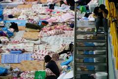 Family members of a missing passenger on board the capsized South Korean ferry Sewol rest as they wait for news from rescue and salvage teams in a makeshift accommodation at a gymnasium in the port ci