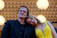 Director Quentin Tarantino and actress Uma Thurman pose on the red carpet they arrive for the screening of the film "Sils Maria" in competition at the 67th Cannes Film Festival in Cannes