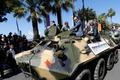 Cast members Arnold Schwarzenegger, Jason Statham and Harrison Ford pose on a tank as they arrive on the Croisette to promote the film "The Expendables 3" during the 67th Cannes Film Festiva