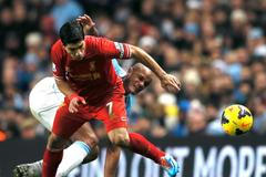 Liverpool's Suarez challenges Manchester City's Kompany during their English Premier League soccer match in Manchester