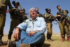 Izraelští vojáci a palestinský farmář v údolí Jordánu