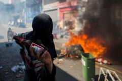 A protester throws a Molotov cocktail at police during a demonstration in Sao Paulo
