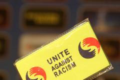 Ukázka karty organizace na protest proti rasismu během tiskové konference fotbalové Sparty Praha.