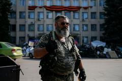 A pro-Russian rebel holds a knife as he stands near a local government building in downtown Kramatorsk