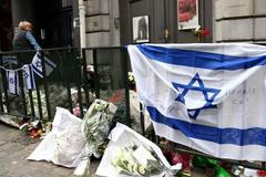 Květiny a izraelské vlajky na místě činu. Před Židovským muzeem v Bruselu.