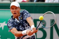 Tomas Berdych of the Czech Republic returns the ball to Ernests Gulbis of Latvia during their men's quarter final match at the French Open Tennis tournament at the Roland Garros stadium in Paris