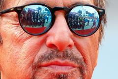 Members of the media are reflected in the sunglasses of cast member Al Pacino as he attends the red carpet for the movie "Manglehorn" at the Venice Film Festival