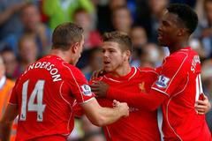 Liverpool's Moreno celebrates with teammates Henderson and Sturridge after scoring his team's third goal during their English Premier League soccer match against Tottenham Hotspur at White Hart Lane i