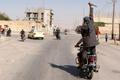 Man holds up a knife as he rides on the back of a motorcycle touring the streets of Tabqa city with others in celebration after Islamic State militants took over Tabqa air base, in nearby Raqqa city