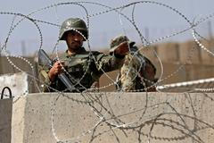 Afghan National Army soldier keeps watch at gate of a British-run military training academy Camp Qargha, in Kabul