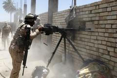 Příslušník iráckých speciálních sil pálí na pozice ISIL západně od Bagdádu.