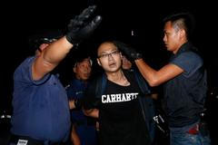Riot policemen detain a pro-democracy protester during a confrontation outside government headquarters in Hong Kong