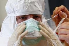A volunteer has his mask adjusted during Red Cross Ebola training excercise in Wuerzburg