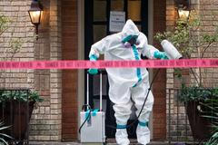 A member of the CG Environmental HazMat team disinfects the entrance to the residence of a health worker at the Texas Health Presbyterian Hospital who has contracted Ebola in Dallas