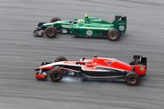 Marussia Formula One driver Bianchi passes Caterham Formula One driver Ericsson during the first practice session of the Malaysian F1 Grand Prix at Sepang International Circuit outside Kuala Lumpur