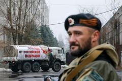 Proruský separatista hlídá v ulicích, kterými právě projíždí ruský konvoj s humanitární pomocí.