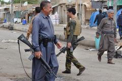 Kurdish fighters guard in the street in the Iraqi town of Qara Tappa north of Baghdad