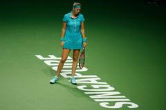 Kvitova of the Czech Republic reacts after losing a point against Radwanska of Poland during their WTA Finals singles tennis match at the Singapore Indoor Stadium