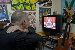 People watch as Cuba's President Raul Castro speaks during a television broadcast in Havana