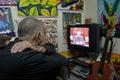People watch as Cuba's President Raul Castro speaks during a television broadcast in Havana