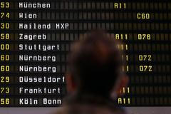 A man looks at cancelled flights by German air carrier Lufthansa on a flight schedule board in Berlin Tegel airport