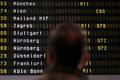 A man looks at cancelled flights by German air carrier Lufthansa on a flight schedule board in Berlin Tegel airport