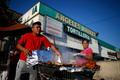 Man cooks meat in a shopping cart in the Westlake area of Los Angeles