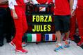 Sign in support of Marussia Formula One driver Jules Bianchi of France is seen among members of Ferrari Formula One team before the first Russian Grand Prix in Sochi