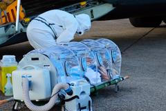 Španělský zdravotník kontroluje pacienta nakaženého ebolou, katolického kněze Manuela Garcia Viejo.