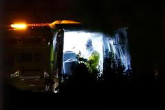 Zdravotník v ochraném vybavení stojí vedle speciálních nosítek se zdravotní sestrou nakaženou ebolou.