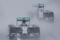 Mercedes Formula One driver Rosberg of Germany leads team mate Hamilton of Britain behind a safety car as they start the first lap of the rain-affected Japanese F1 Grand Prix at the Suzuka Circuit