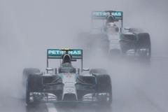 Mercedes Formula One driver Rosberg of Germany leads team mate Hamilton of Britain behind a safety car as they start the first lap of the rain-affected Japanese F1 Grand Prix at the Suzuka Circuit
