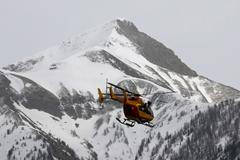 A rescue helicopter from the French Securite Civile flies over the French Alps during a rescue operation next to the crash site of an Airbus A320
