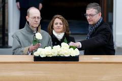 Michael Ibsen (L), a direct descendant of RichardPřímý potomek Richarda III. Michael Ibsen umístil růži na královské rakvi během obřadu v Leicesterské univerzitě ve střední Anglii.er, central England