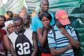 People stand outside the morgue where the dead bodies of people killed when a carnival float hit power lines, had been taken to, in Port-au-Prince
