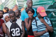 People stand outside the morgue where the dead bodies of people killed when a carnival float hit power lines, had been taken to, in Port-au-Prince