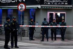 Police officers control the street in front of an internet cafe in Copenhagen
