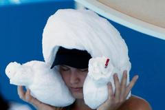 Eugenie Bouchard of Canada sits with an ice-packed towel over her head during a break in play in her women's singles match against Lauren Davis of the U.S. at the Australian Open 2014 tennis tournamen