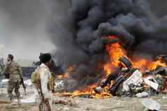 Příslušníci iráckých šíitských milic kolem automobilu se sebevražedným atentátníkem Islámského státu.