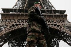 Voják hlídkuje před Eiffelovou věží.